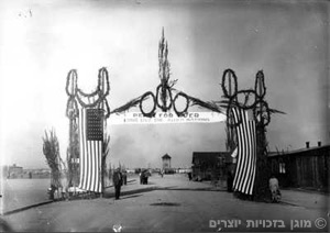 שער מחנה הריכוז דכאו מקושט בדגלי ארצות-הברית לאחר השחרור