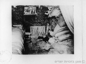 יהודי מציץ מתוך פתח בונקר במהלך מרד גטו ורשה בשנת 1943
